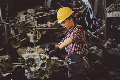 woman with yellow hard hat holding machinery