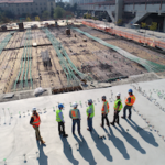 Construction workers overlooking a work site.