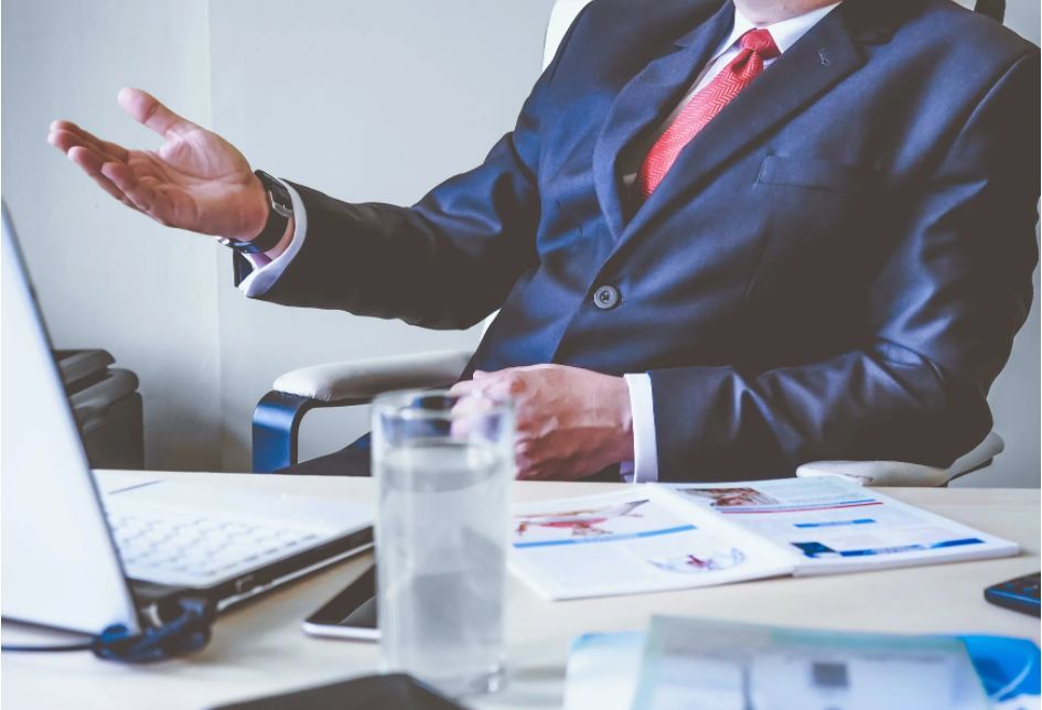 A man in a suit behind a desk