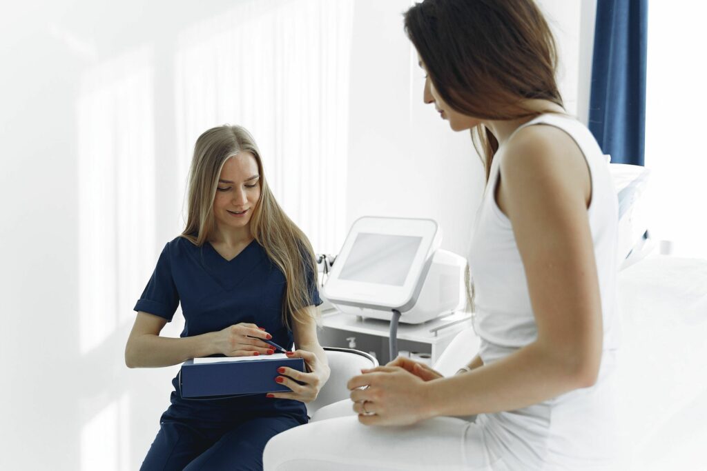 Nurse conferring with patient in examination room.