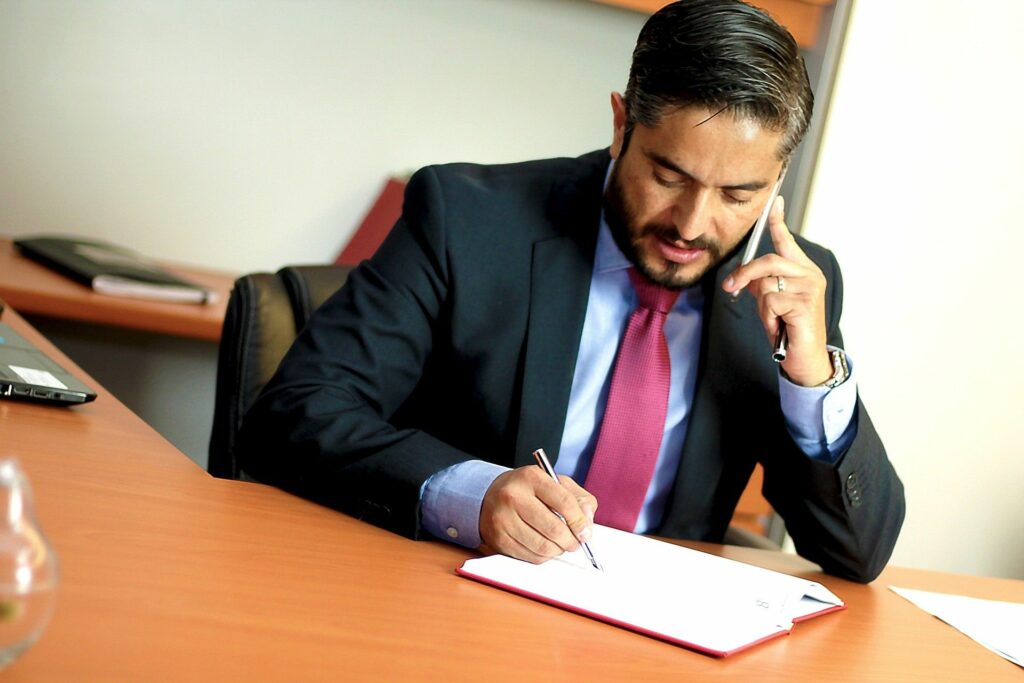 A lawyer on the phone taking notes.