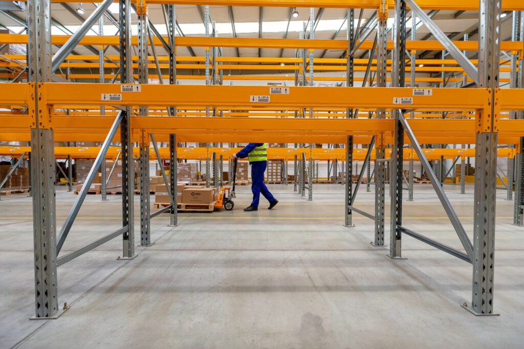 A warehouse employee pushing a pallet jack