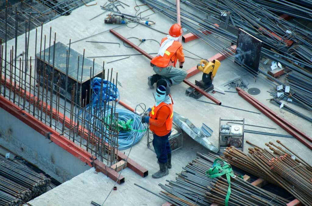 Construction workers doing their job while trying to avoid injury. 