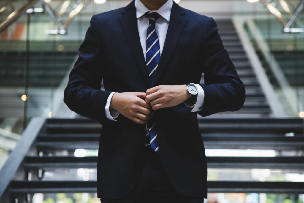 A man walking down stairs wearing a nice suit and tie