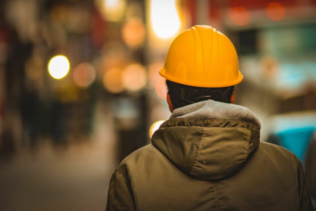 A man wearing a hardhat walking away from the camera