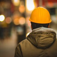 A man wearing a hardhat walking away from the camera