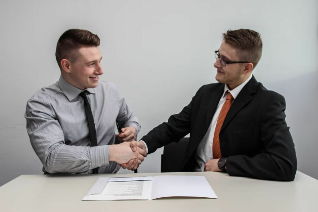 Two men shaking hands during a job interview