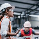 Female industrial engineer wearing a white helmet while standing