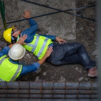 A young Asian builder falls from a scaffold at a construction site. An engineer supervising the construction came to the aid of a construction worker who fell from a height with hip and leg injuries.