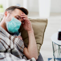 Ill man sleeping with a face mask
