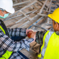 Physical injury at work of construction worker. Injury bleeding from work accident in pile of scaffolding steel falling down to impinge the arm. Physical injury at work of construction worker. Injury bleeding from work accident in pile of scaffolding steel falling down to impinge the arm.