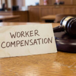 Worker compensation legal claim concept with judge gavel in courtroom setting representing occupational injury lawsuit employee rights enforcement and workplace injury financial settlement process